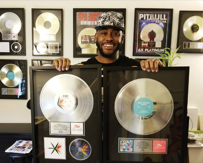 Otha 'Vakseen' Davis III poses for a photo with his K-pop plaques.